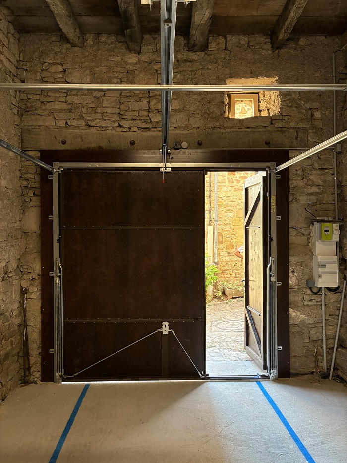 Vue intérieure du portail fermé avec les rails de guidage fixés sur les cornières perforées au plafond